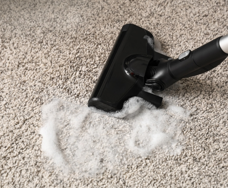 Experienced cleaner removing dirt and stains from carpeted stairs in Fort Washington